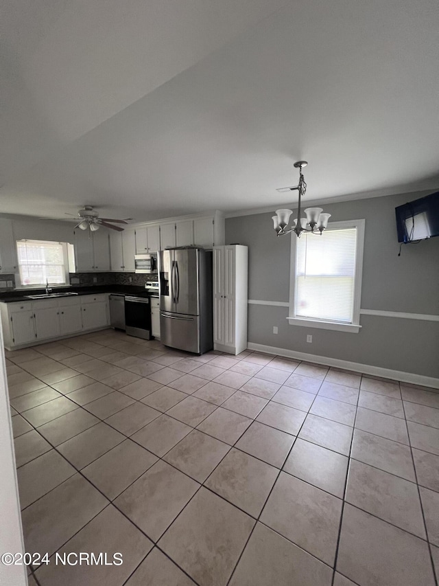 kitchen with sink, ceiling fan with notable chandelier, white cabinets, stainless steel appliances, and light tile patterned floors