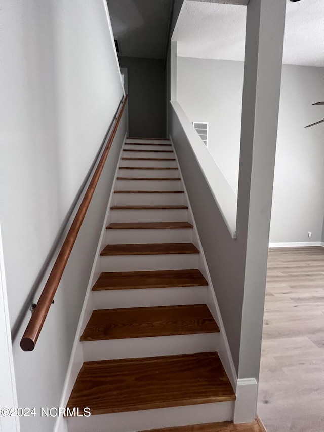 staircase with hardwood / wood-style floors