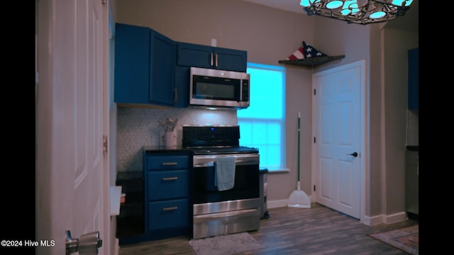 kitchen with tasteful backsplash, dark hardwood / wood-style flooring, blue cabinets, and appliances with stainless steel finishes