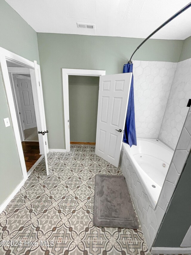 bathroom featuring tile patterned floors and tiled shower / bath