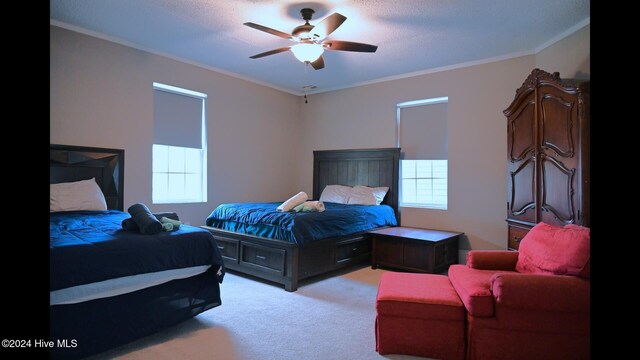 carpeted bedroom with ceiling fan, crown molding, and a textured ceiling