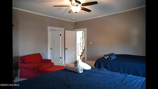 bedroom featuring a textured ceiling, ceiling fan, and crown molding