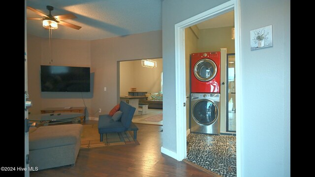 laundry room featuring a textured ceiling, dark hardwood / wood-style floors, stacked washer / dryer, and ceiling fan