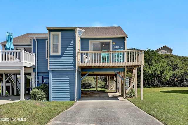 raised beach house with a front yard and a carport