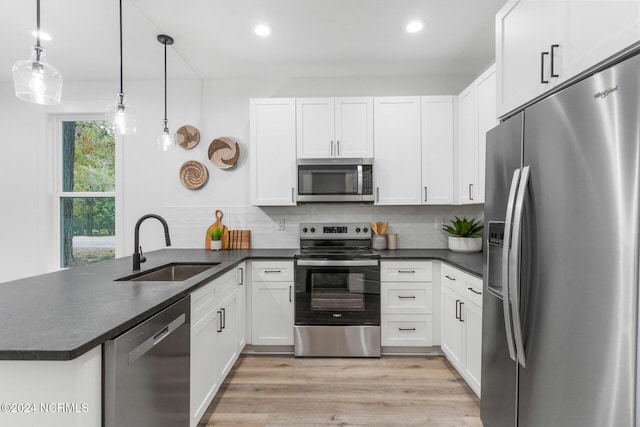 kitchen featuring appliances with stainless steel finishes, kitchen peninsula, and white cabinetry