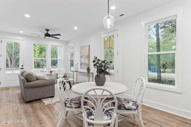 dining area with light wood-type flooring and ceiling fan