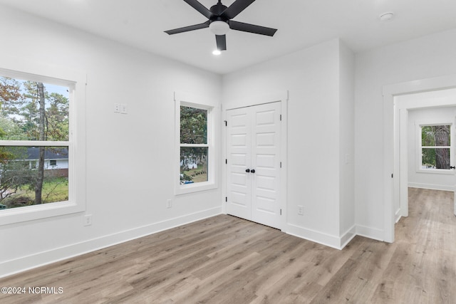 unfurnished room featuring ceiling fan, plenty of natural light, and light wood-type flooring