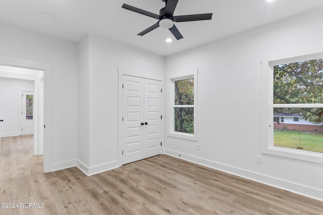 empty room with light hardwood / wood-style flooring, a healthy amount of sunlight, and ceiling fan