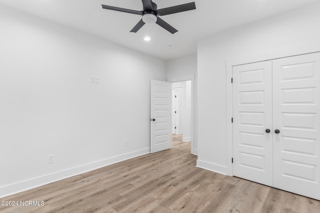 unfurnished bedroom with light hardwood / wood-style floors, a closet, and ceiling fan