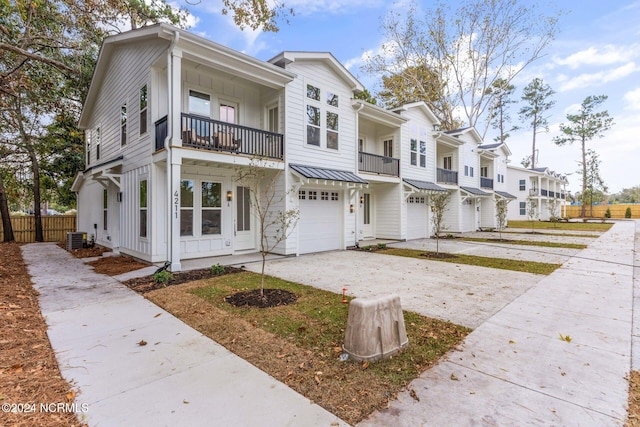 townhome / multi-family property with central AC, a balcony, and a garage