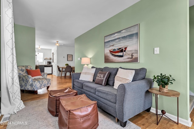 living room featuring light wood-type flooring and sink