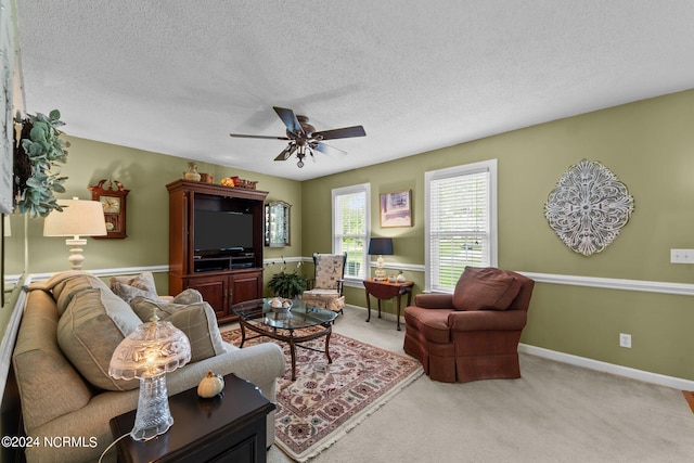 carpeted living room featuring ceiling fan and a textured ceiling