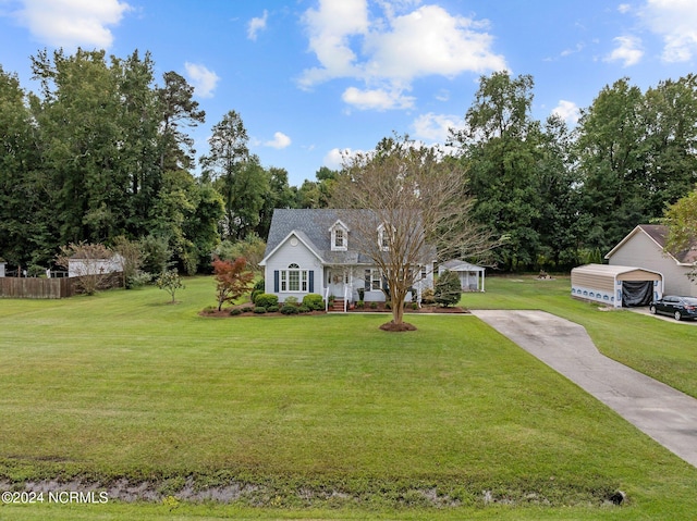 new england style home with a garage, a front lawn, and an outbuilding