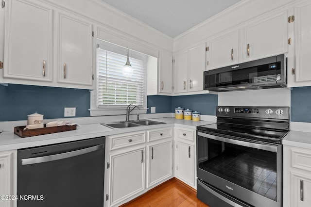 kitchen featuring sink, light hardwood / wood-style flooring, white cabinetry, appliances with stainless steel finishes, and crown molding