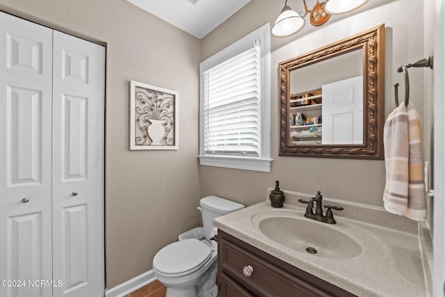 bathroom featuring an inviting chandelier, vanity, and toilet