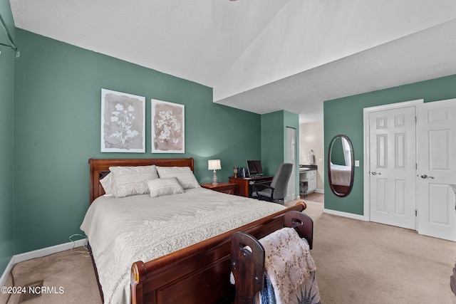 bedroom featuring light colored carpet and lofted ceiling