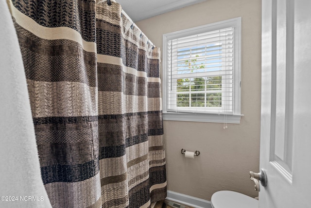 bathroom with curtained shower and toilet