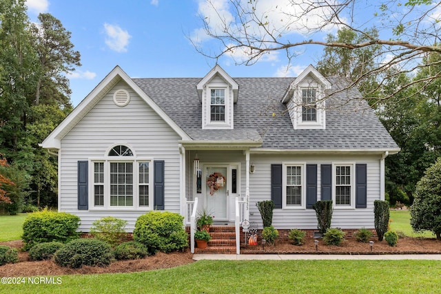 cape cod-style house featuring a front yard