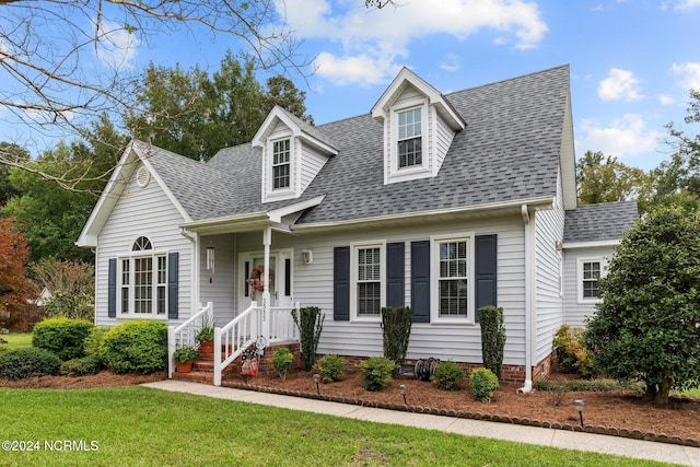 cape cod house with a front lawn