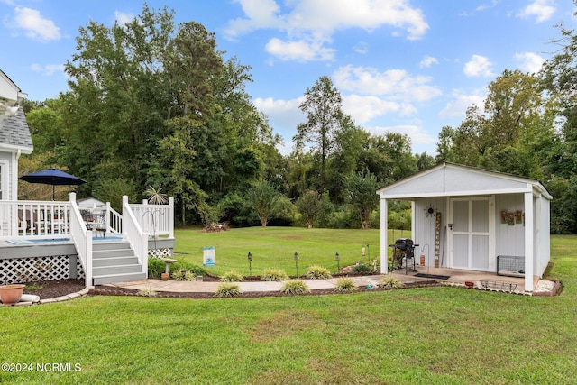 view of yard featuring an outdoor structure and a deck