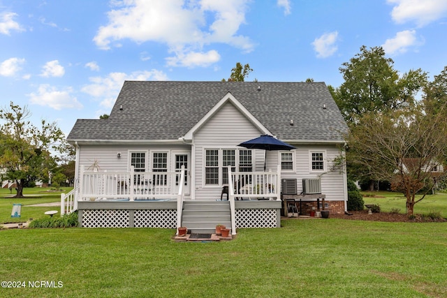 rear view of property featuring a deck and a yard