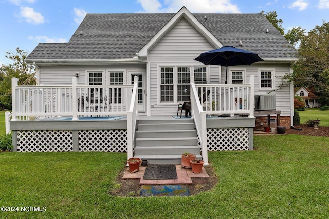 rear view of house featuring a yard and a deck