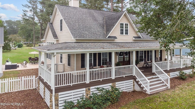 306 4th St, Pollocksville, NC 28573 - view of front of home featuring a patio, a shingled roof, fence, and a chimney