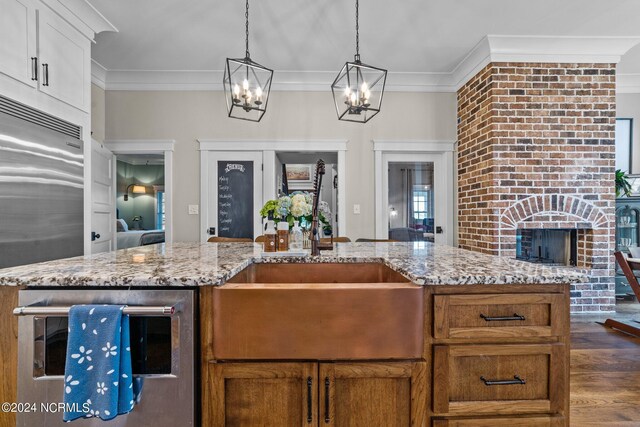 306 4th St, Pollocksville, NC 28573 - kitchen featuring dark wood finished floors, crown molding, a sink, and an inviting chandelier