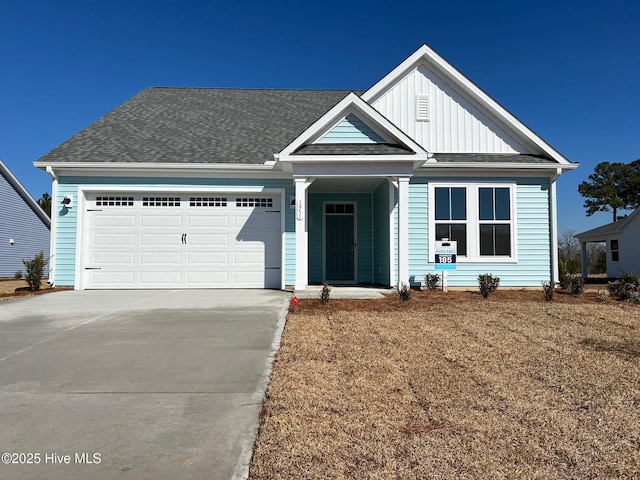 1951 Mansfield Ave SE, Bolivia, NC 28422 - view of front of house with board and batten siding, an attached garage, driveway, and roof with shingles