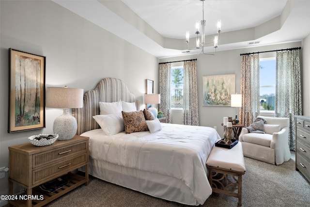 bedroom with a notable chandelier, a tray ceiling, and carpet