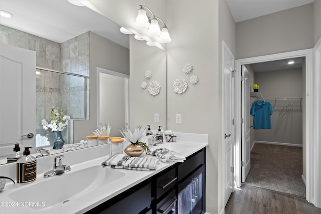 bathroom with vanity, hardwood / wood-style floors, a shower with shower door, and an inviting chandelier