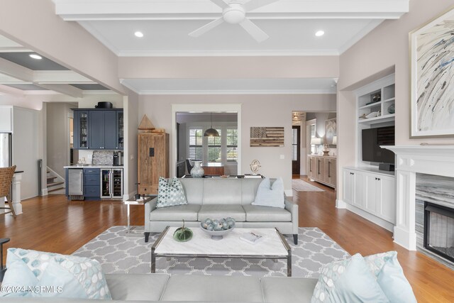 living room featuring a premium fireplace, wood finished floors, visible vents, built in features, and beamed ceiling