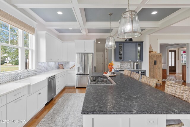 dining area with beam ceiling, visible vents, crown molding, and wood finished floors