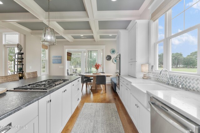 kitchen with stainless steel appliances, dark countertops, white cabinetry, and a kitchen island