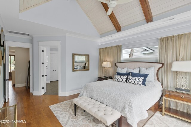 bedroom featuring multiple windows, light wood finished floors, beamed ceiling, and visible vents