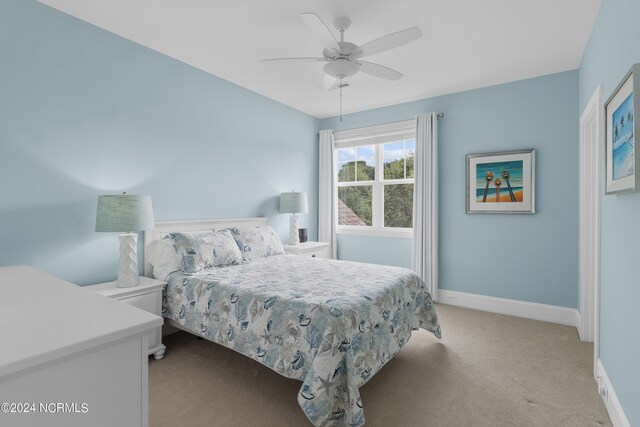 bedroom featuring ceiling fan, baseboards, and light colored carpet