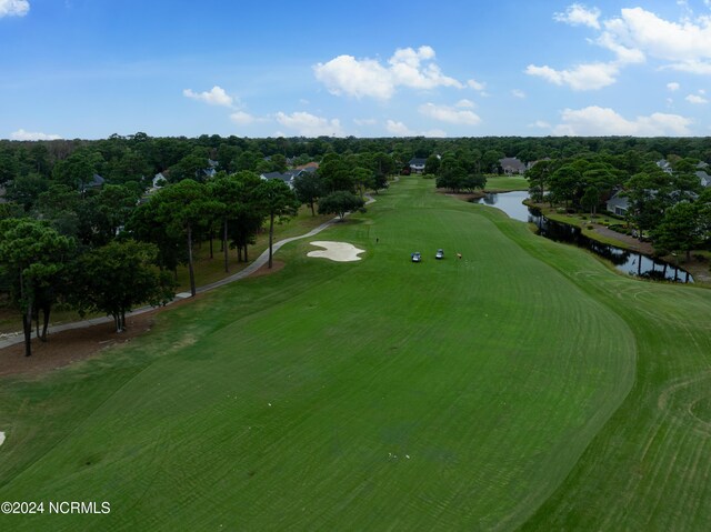 surrounding community featuring view of golf course and a lawn