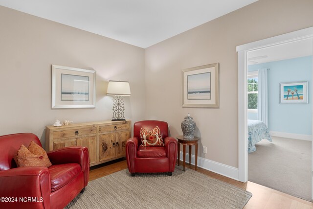 living room with baseboards, a ceiling fan, light colored carpet, stairway, and vaulted ceiling