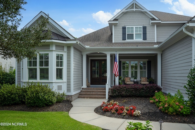 view of exterior entry with a shingled roof