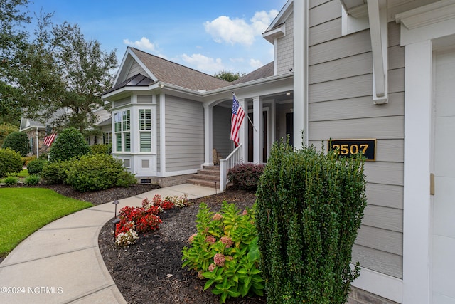 doorway to property featuring a shingled roof