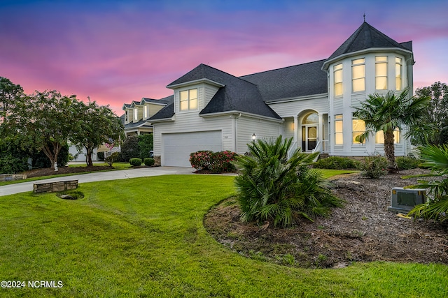 view of front of property featuring a lawn and a garage