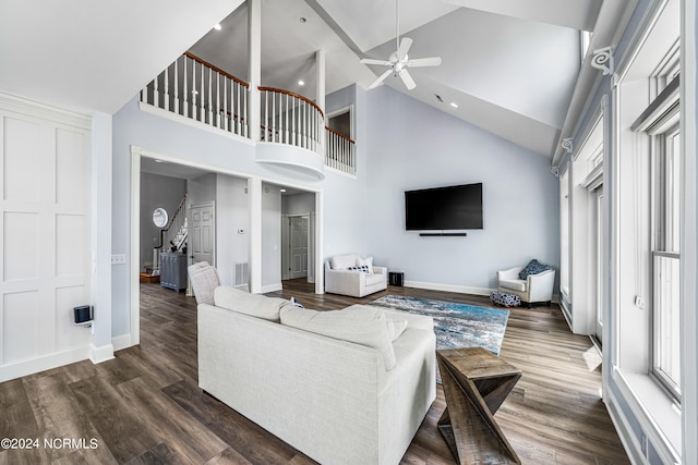 living room with dark wood-type flooring, ceiling fan, and high vaulted ceiling