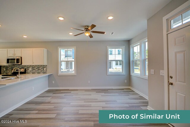 kitchen featuring refrigerator, light wood-style floors, visible vents, and a sink