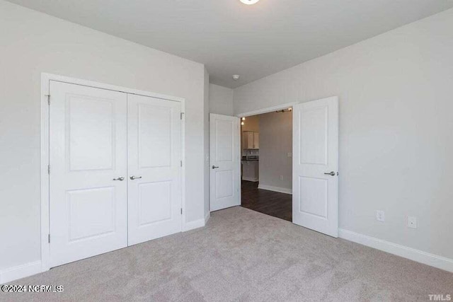 unfurnished bedroom with dark colored carpet and a closet