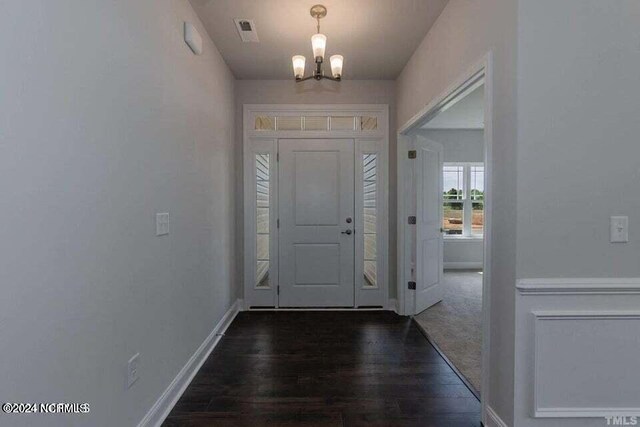 entryway with an inviting chandelier and dark hardwood / wood-style floors