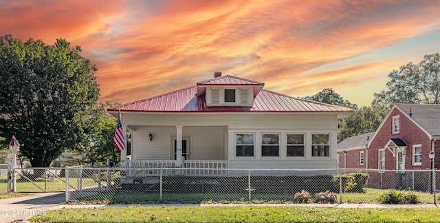 view of front facade featuring covered porch and a yard