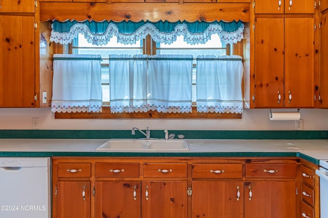 kitchen featuring white appliances, sink, and plenty of natural light