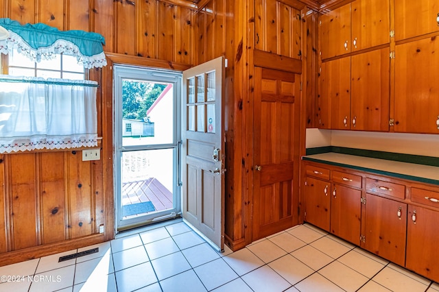 kitchen featuring wooden walls and light tile patterned floors