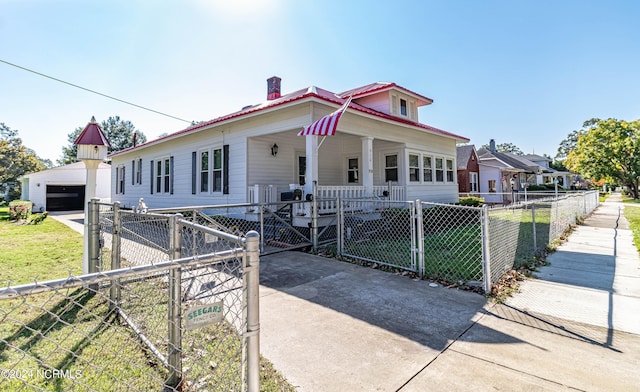 view of front of home featuring a porch, a garage, and a front lawn