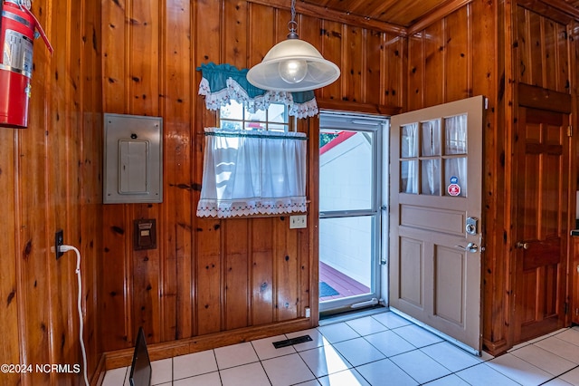 tiled foyer featuring electric panel and wood walls